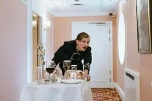 Man in hotel room delivering room service 